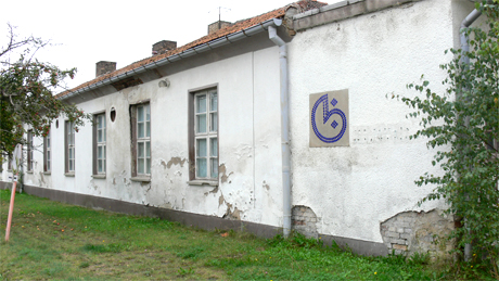 Eines der einstöckigen Gebäude der Gablona aus der Anfangszeit der Fabrik. An der Fassade gut zu erkennen ist das alte Firmenlogo des VEB Gablona.