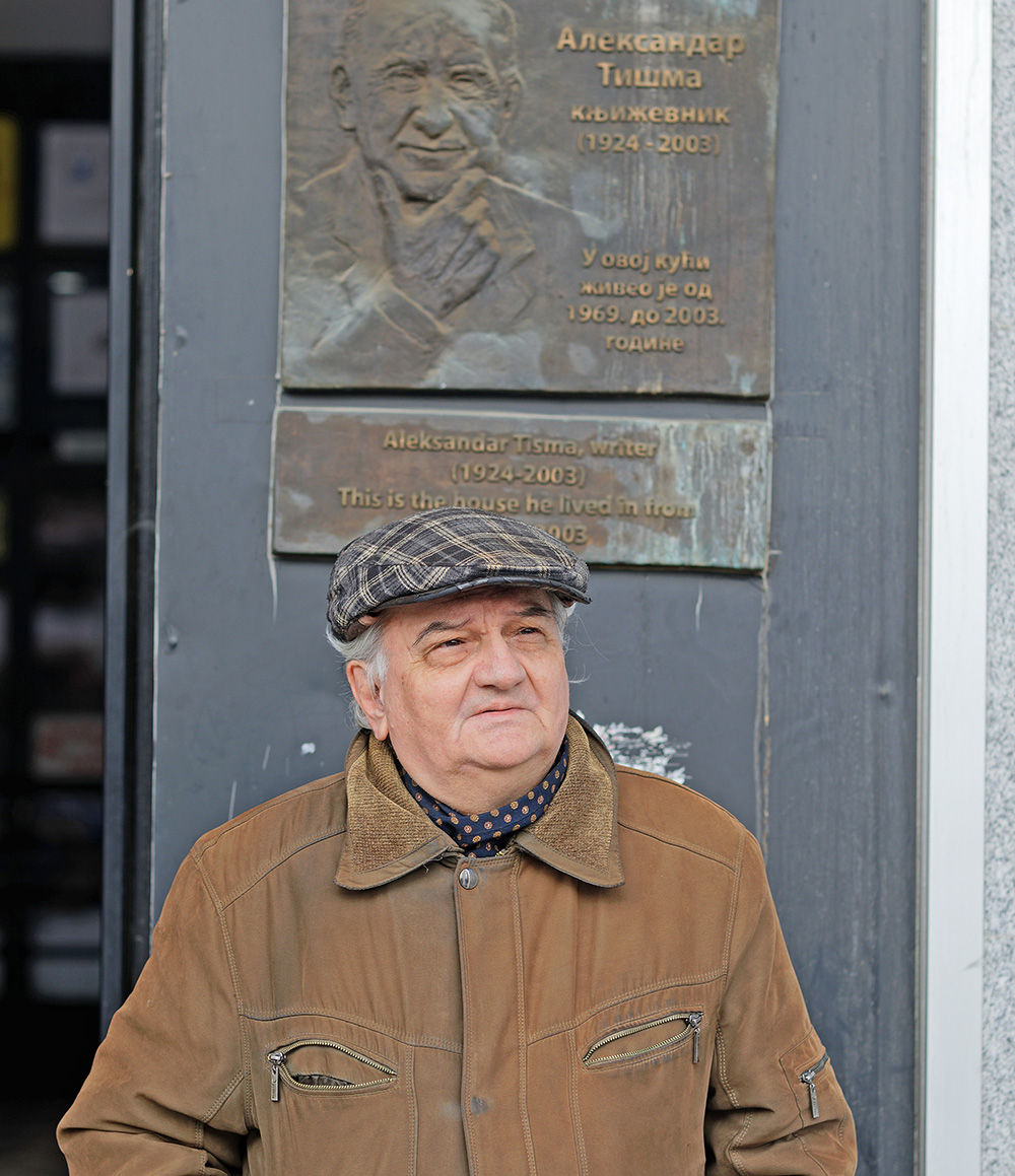 Andrej Tišma vor der Plakette, die an seinen Vater Aleksandar erinnert. © Boris Radivojkov