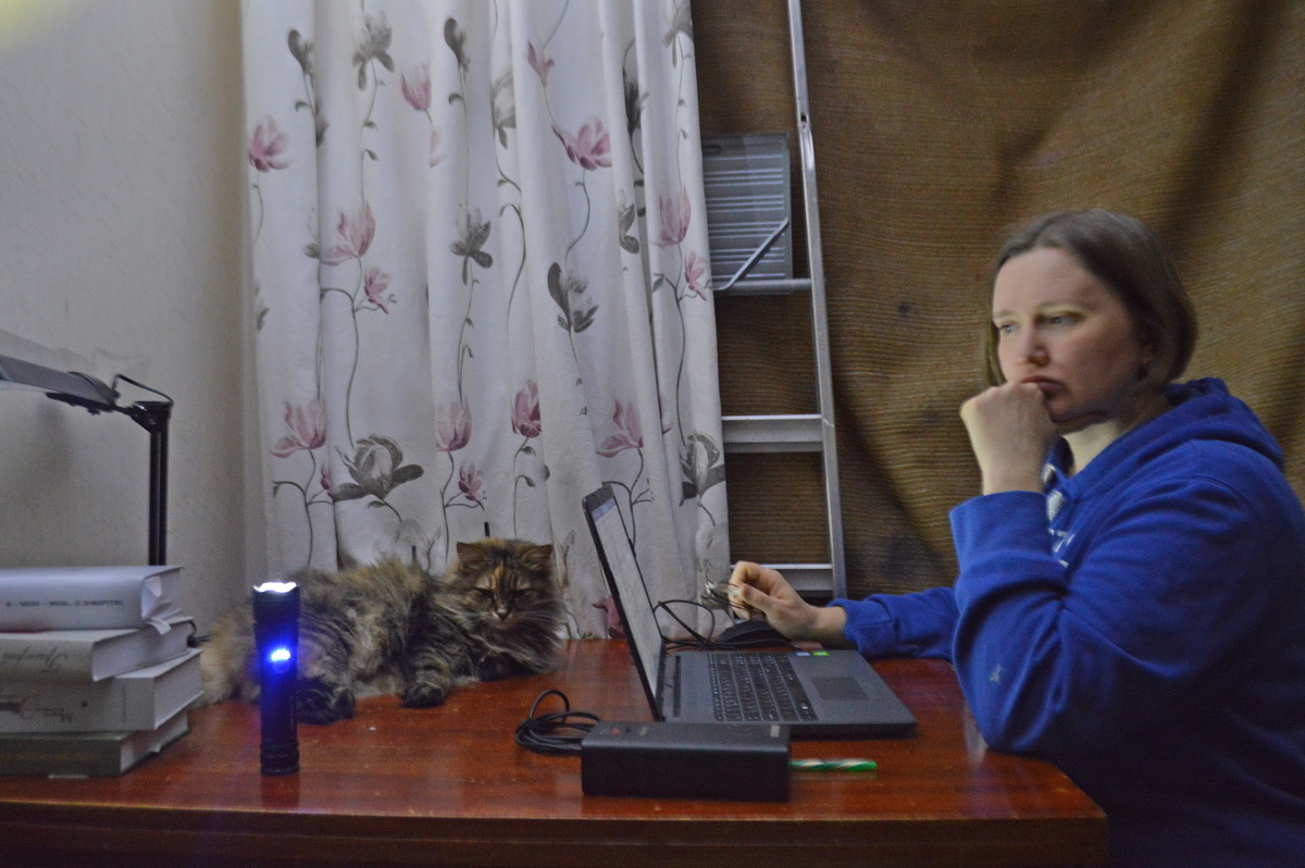 Der Strom ausgefallen, die Fenster abgedunkelt: Nataliia Vusatiuk arbeitet mit einer Powerbank und Taschenlampe an ihrem Manuskript. Foto: © Andrii Vusatiuk